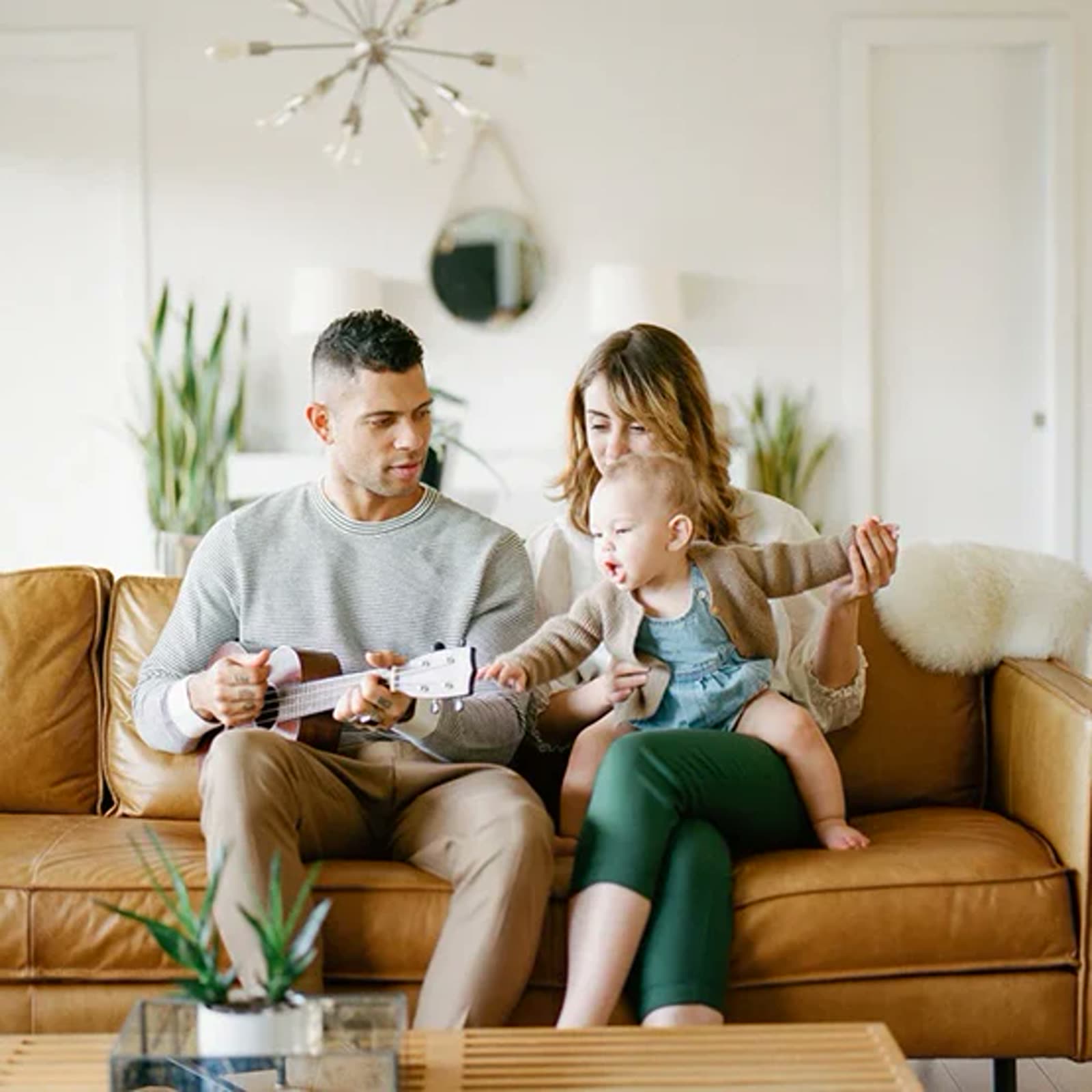 A family sitting on a cognac leather sofa, the hide already taking the shape of a life